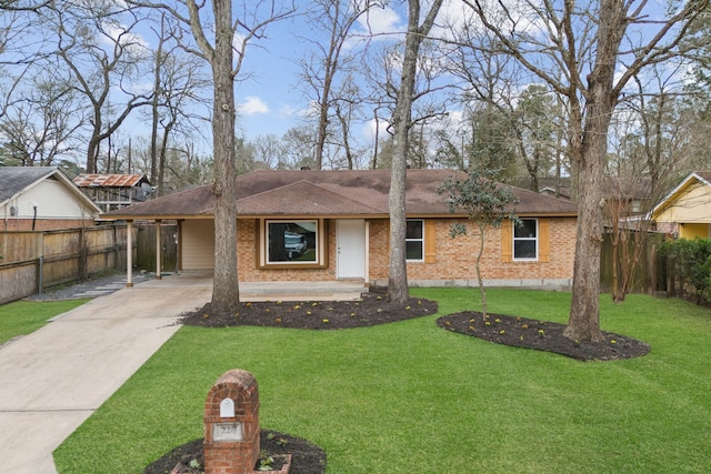 ranch-style house with a carport, fence, concrete driveway, a front yard, and brick siding