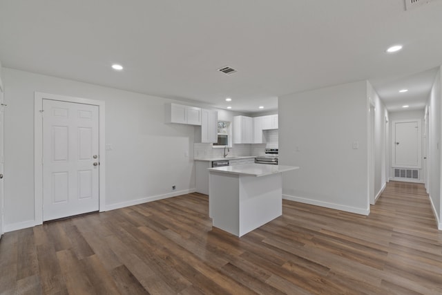 kitchen featuring tasteful backsplash, visible vents, light countertops, dark wood-style floors, and white cabinets