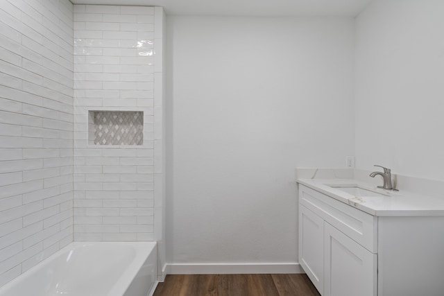 bathroom featuring vanity, shower / bathtub combination, baseboards, and wood finished floors