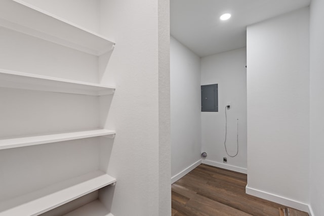 laundry area with dark wood finished floors, electric panel, recessed lighting, and baseboards