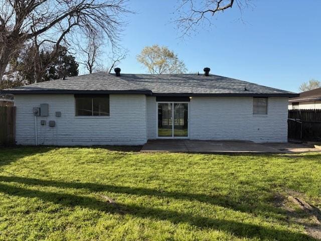 rear view of house featuring a yard and fence