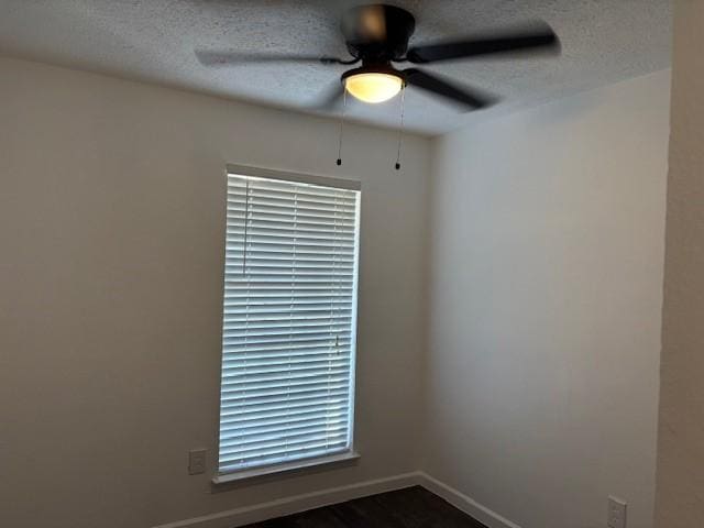 empty room featuring a ceiling fan, baseboards, and a textured ceiling