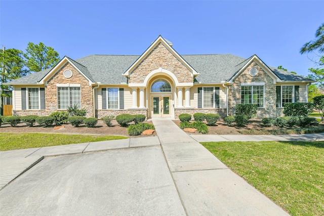 view of front of house with french doors and roof with shingles