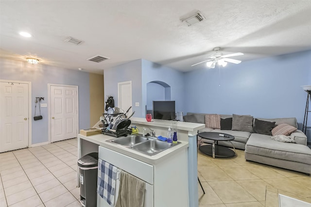 kitchen with visible vents, open floor plan, light countertops, light tile patterned flooring, and a sink