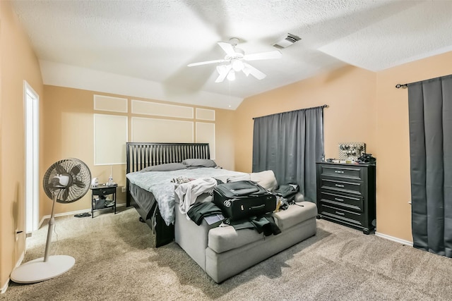 carpeted bedroom featuring visible vents, baseboards, vaulted ceiling, a textured ceiling, and a ceiling fan