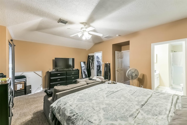 carpeted bedroom with visible vents, a textured ceiling, a closet, a spacious closet, and vaulted ceiling