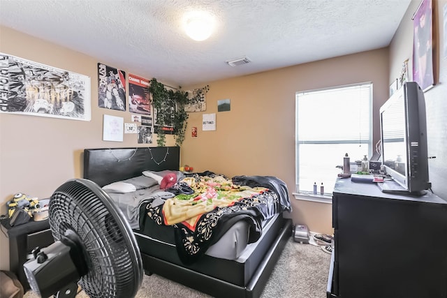 carpeted bedroom with visible vents and a textured ceiling