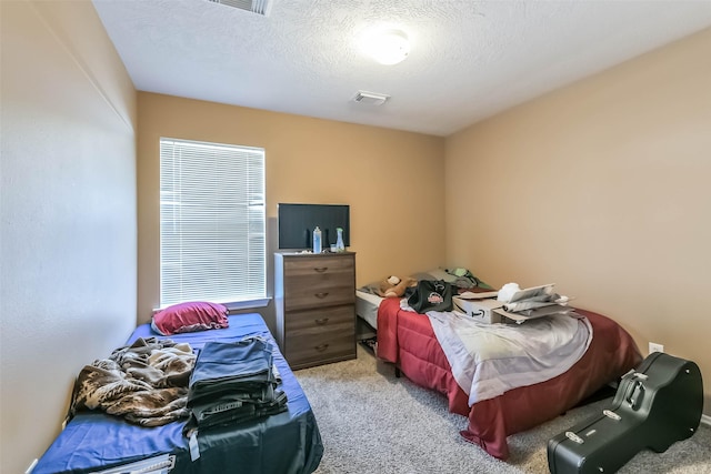 carpeted bedroom featuring visible vents and a textured ceiling