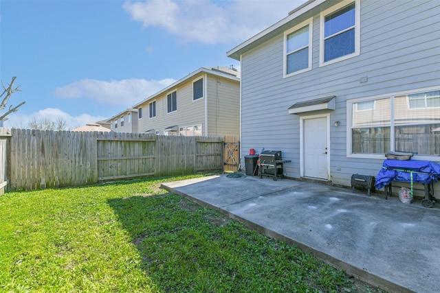 rear view of house with a patio area, a lawn, and a fenced backyard