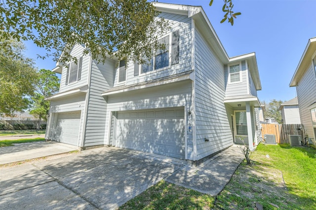 traditional home featuring a garage, a front yard, driveway, and fence