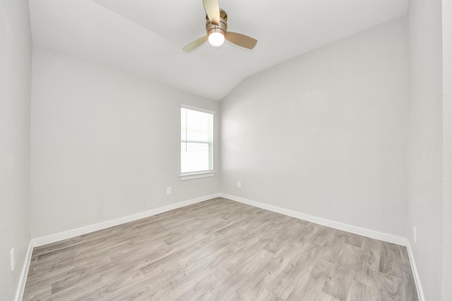 empty room featuring a ceiling fan, lofted ceiling, light wood-style floors, and baseboards