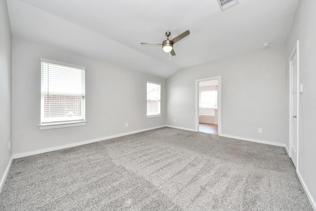 carpeted spare room featuring visible vents, baseboards, a ceiling fan, and vaulted ceiling