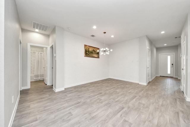 spare room featuring an inviting chandelier, recessed lighting, visible vents, and light wood-type flooring