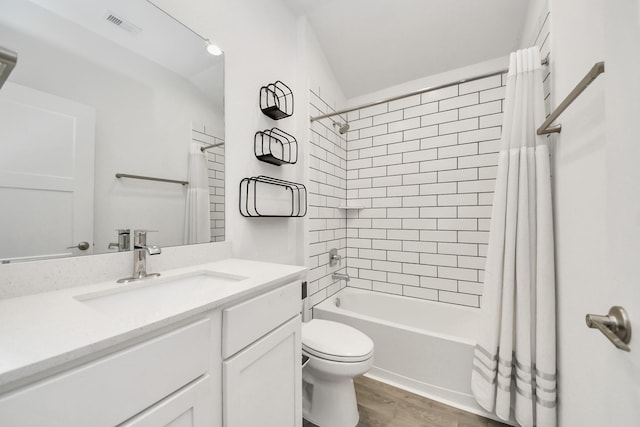 bathroom with visible vents, toilet, shower / bath combo, wood finished floors, and vanity