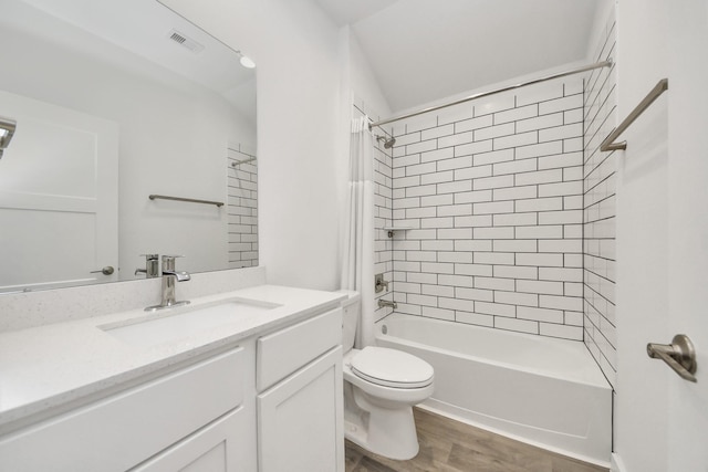 bathroom with vanity, wood finished floors, visible vents, bathtub / shower combination, and toilet