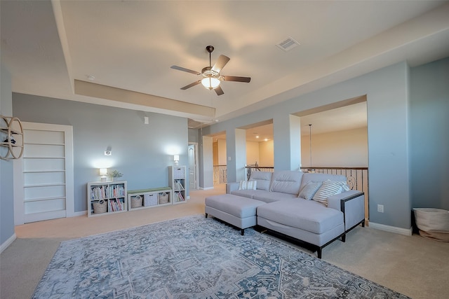 carpeted living area featuring baseboards, visible vents, and ceiling fan