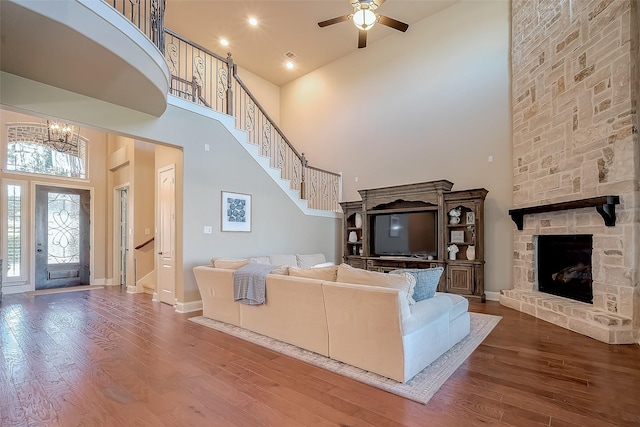 unfurnished living room featuring stairs, wood finished floors, and a towering ceiling