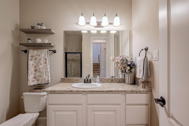 bathroom with vanity, toilet, and a stall shower