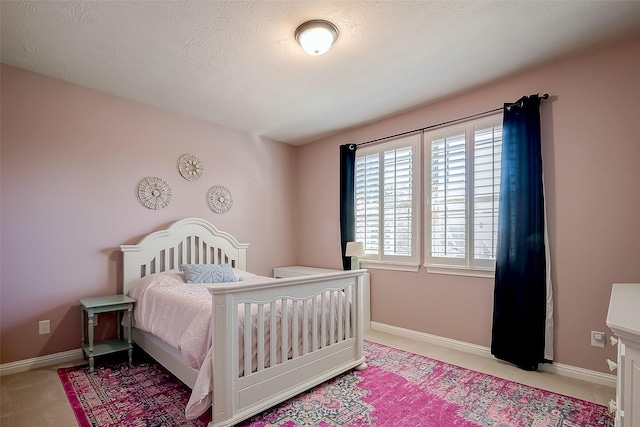 bedroom with light colored carpet and baseboards