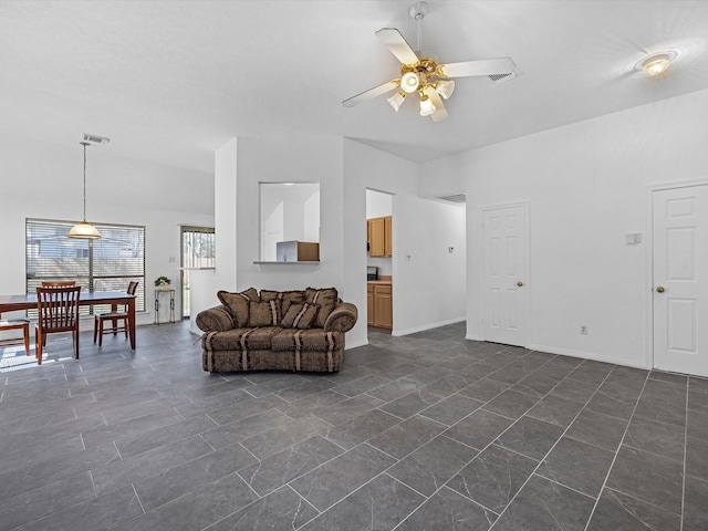 living room with visible vents, baseboards, and a ceiling fan