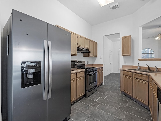 kitchen with under cabinet range hood, light countertops, stainless steel appliances, a ceiling fan, and a sink