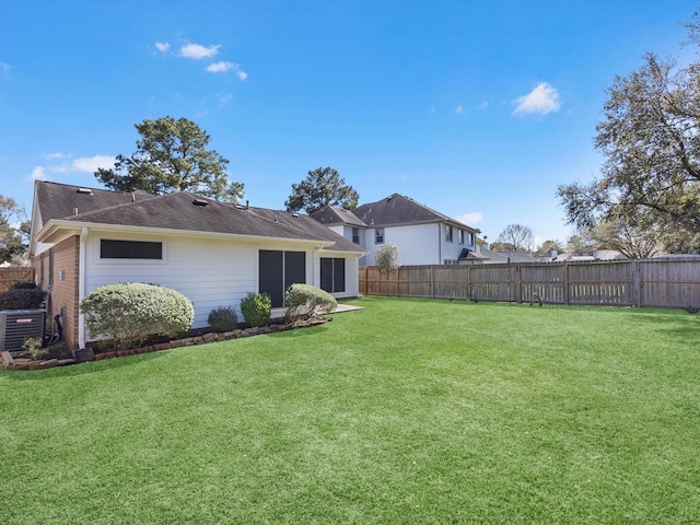 back of property with cooling unit, a yard, and fence