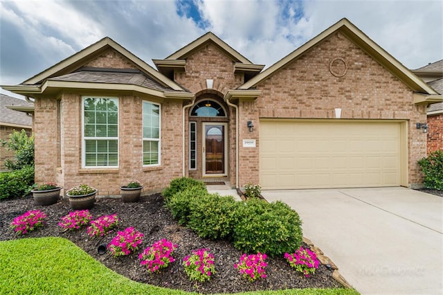 view of front of house with brick siding, an attached garage, and concrete driveway