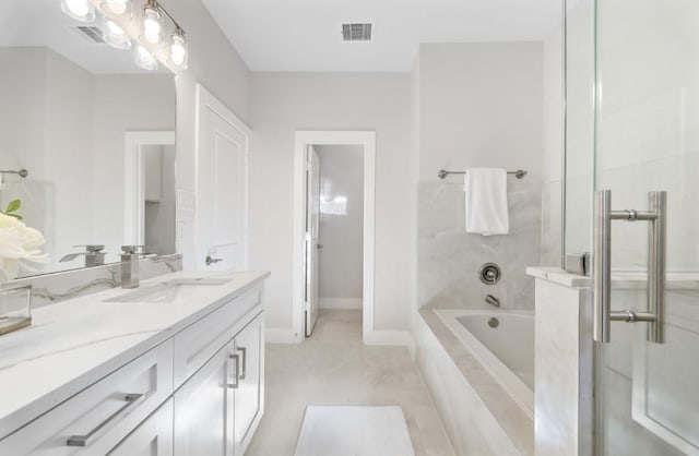 bathroom with visible vents, tiled bath, a shower, baseboards, and vanity