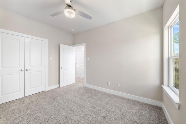 unfurnished bedroom with a closet, a ceiling fan, baseboards, and carpet floors