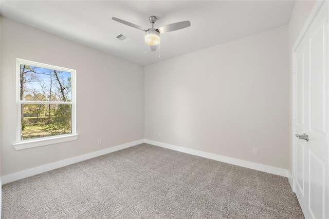 unfurnished room with carpet flooring, baseboards, visible vents, and ceiling fan