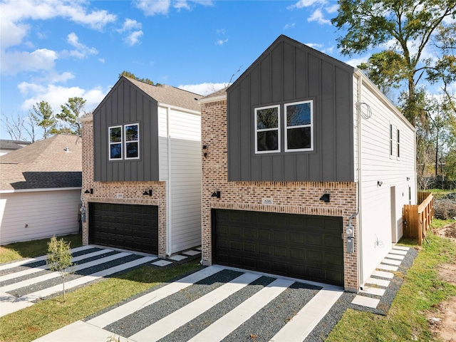 view of front of house with an attached garage, brick siding, and board and batten siding