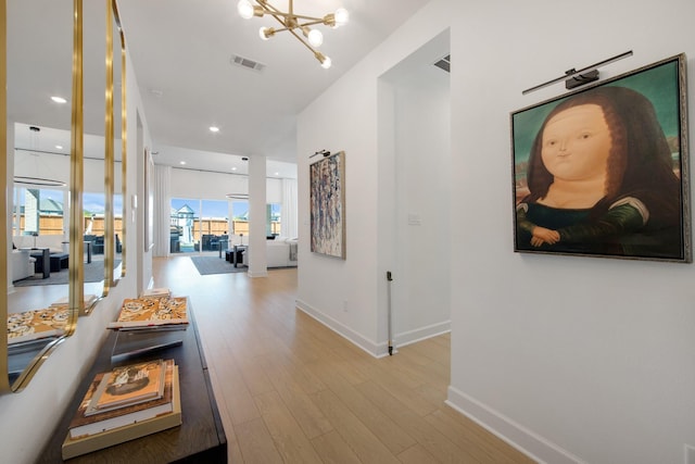 corridor featuring visible vents, baseboards, a chandelier, recessed lighting, and wood finished floors