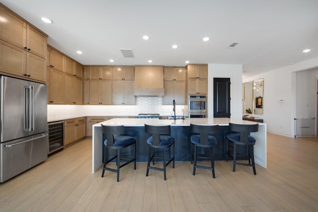 kitchen featuring beverage cooler, visible vents, premium range hood, decorative backsplash, and appliances with stainless steel finishes