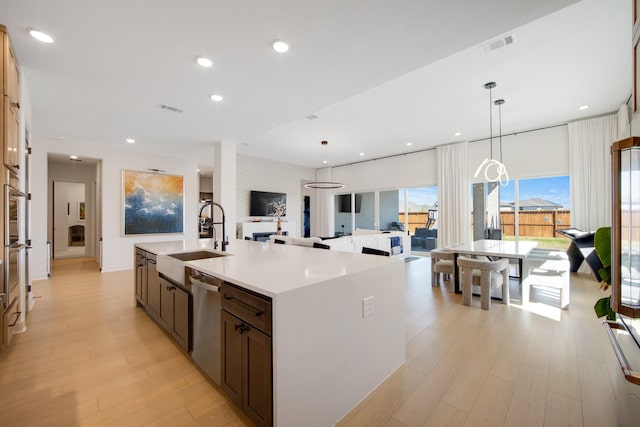 kitchen featuring a sink, visible vents, light wood-style floors, and stainless steel appliances