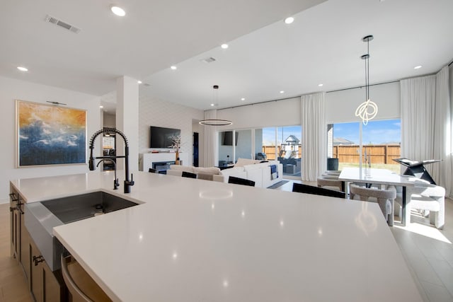 kitchen featuring visible vents, recessed lighting, light countertops, and a sink