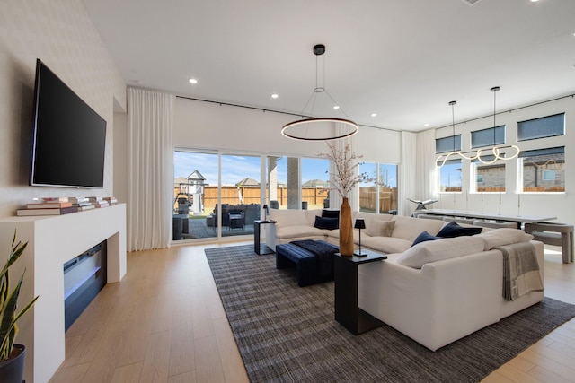 living area featuring recessed lighting, wood finished floors, and a fireplace