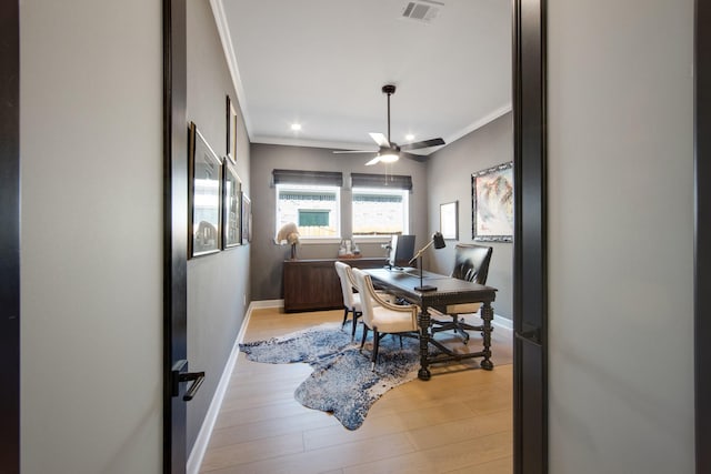 office area featuring visible vents, light wood-style floors, and ornamental molding