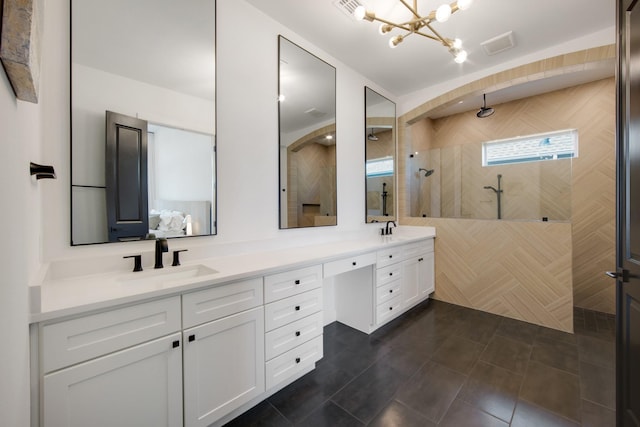 bathroom with a sink, walk in shower, double vanity, and tile patterned floors