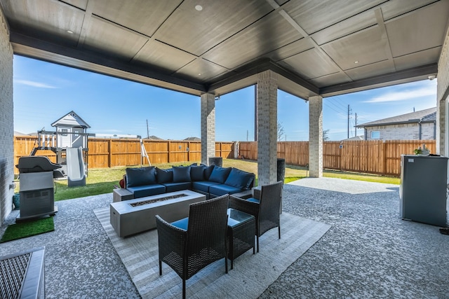 view of patio with an outdoor living space with a fire pit and a fenced backyard