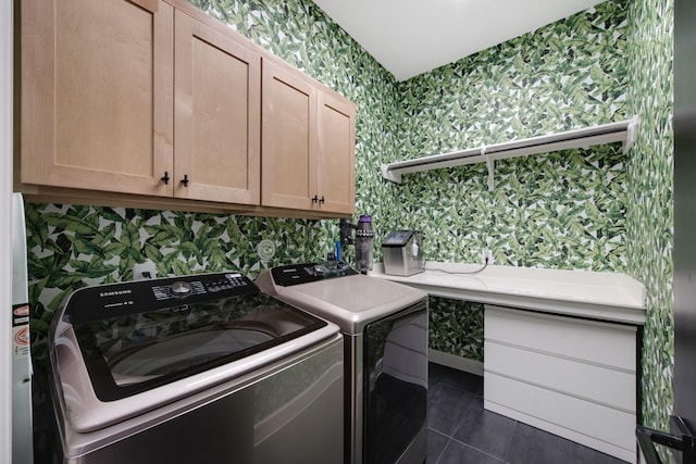 clothes washing area featuring cabinet space, wallpapered walls, dark tile patterned flooring, and separate washer and dryer