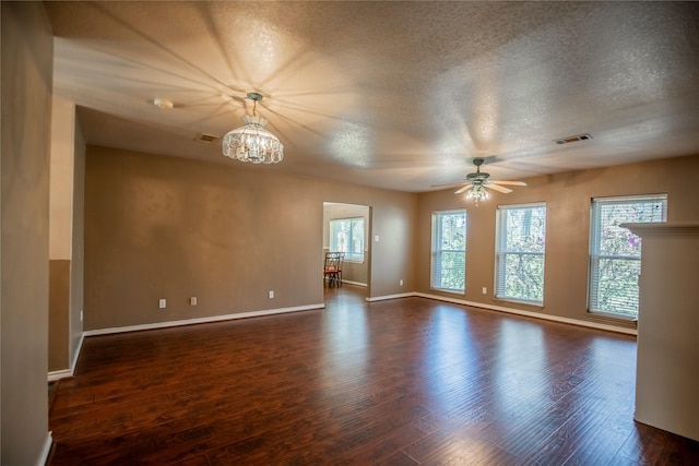 unfurnished room with baseboards, visible vents, dark wood-style flooring, and a textured ceiling