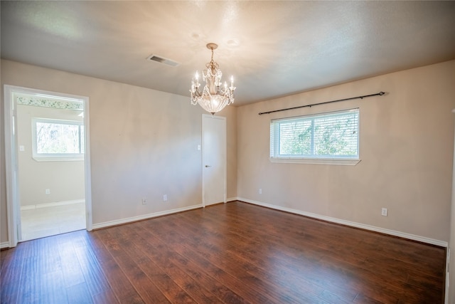 unfurnished room featuring plenty of natural light, dark wood-style floors, visible vents, and baseboards