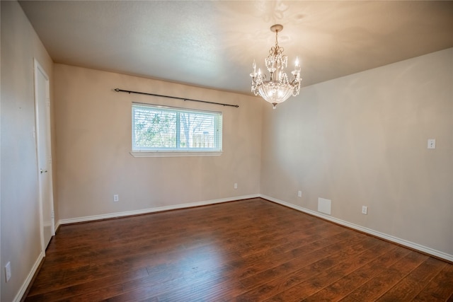 empty room featuring baseboards, a chandelier, and dark wood-style flooring