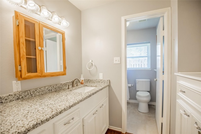 bathroom featuring tile patterned flooring, toilet, vanity, and baseboards