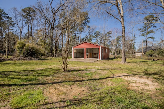 view of yard with an outdoor structure, fence, a garage, and driveway