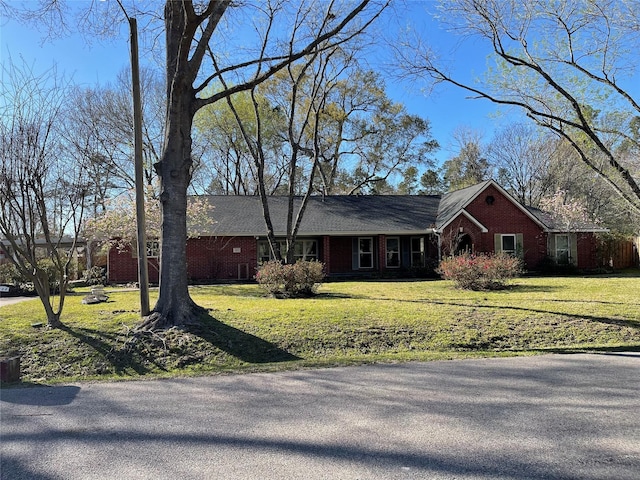 single story home featuring brick siding and a front yard