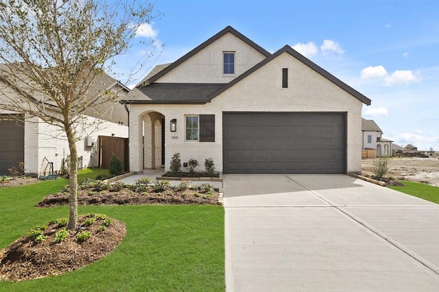 view of front of property featuring concrete driveway, a garage, a front yard, and stucco siding