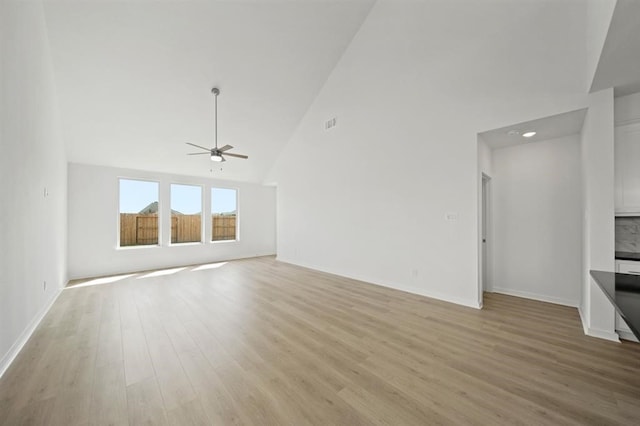 unfurnished living room featuring visible vents, baseboards, light wood-style flooring, high vaulted ceiling, and a ceiling fan