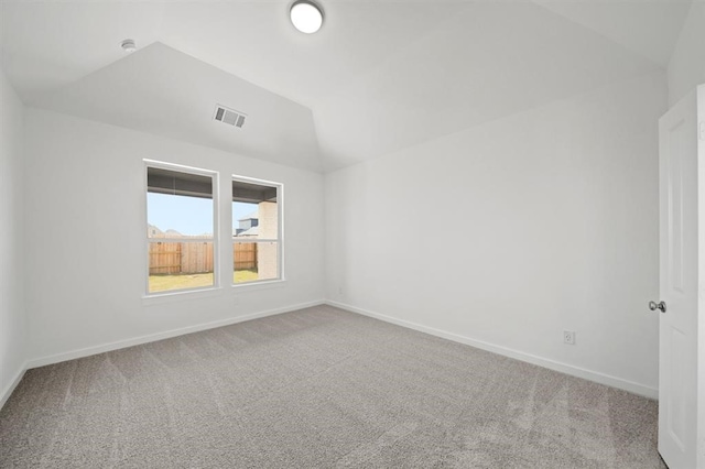 carpeted spare room with visible vents, baseboards, and vaulted ceiling