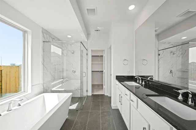 full bath featuring a walk in closet, visible vents, a marble finish shower, and a sink